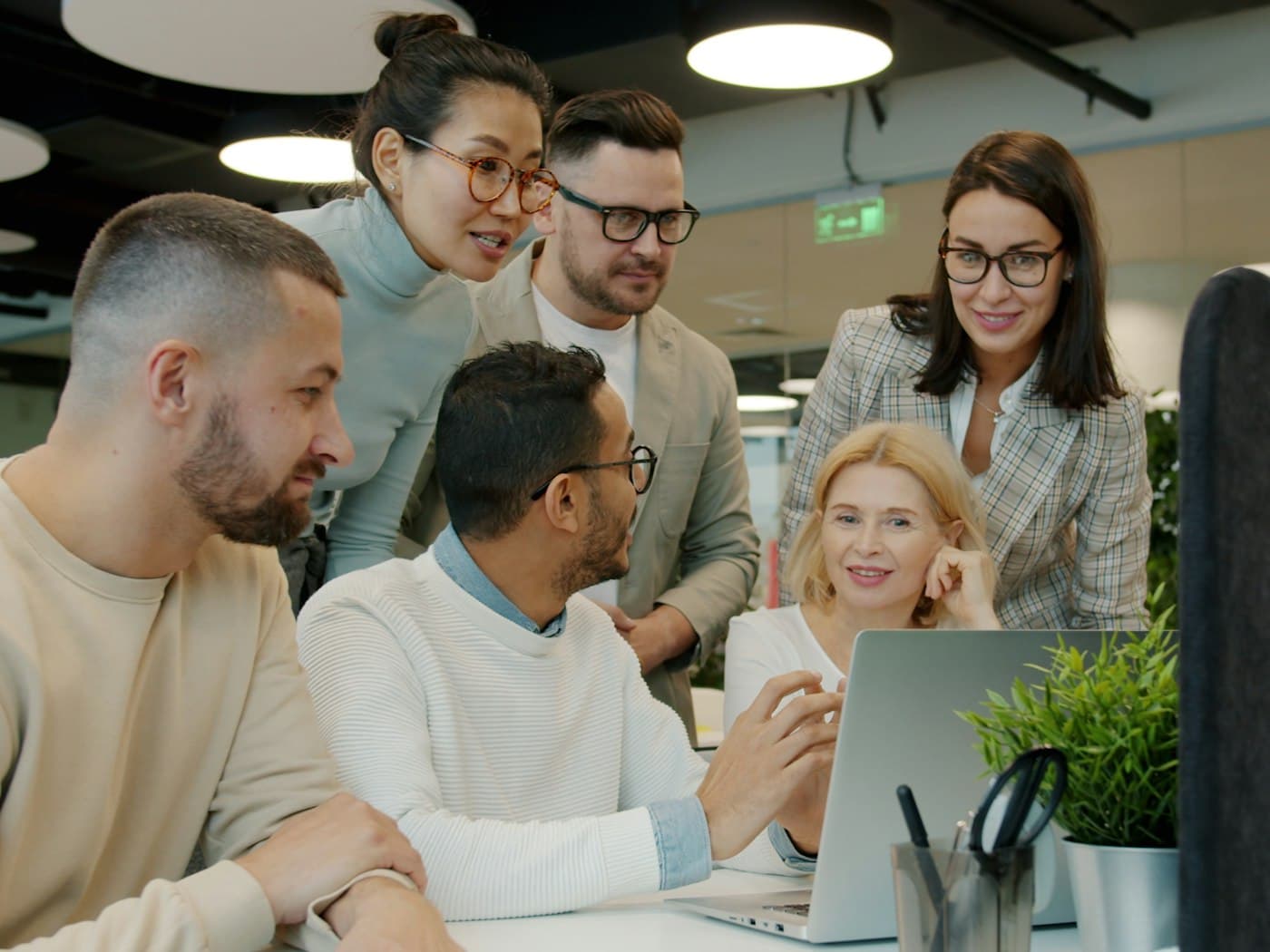 Equipe de escritório reunida em volta de um notebook